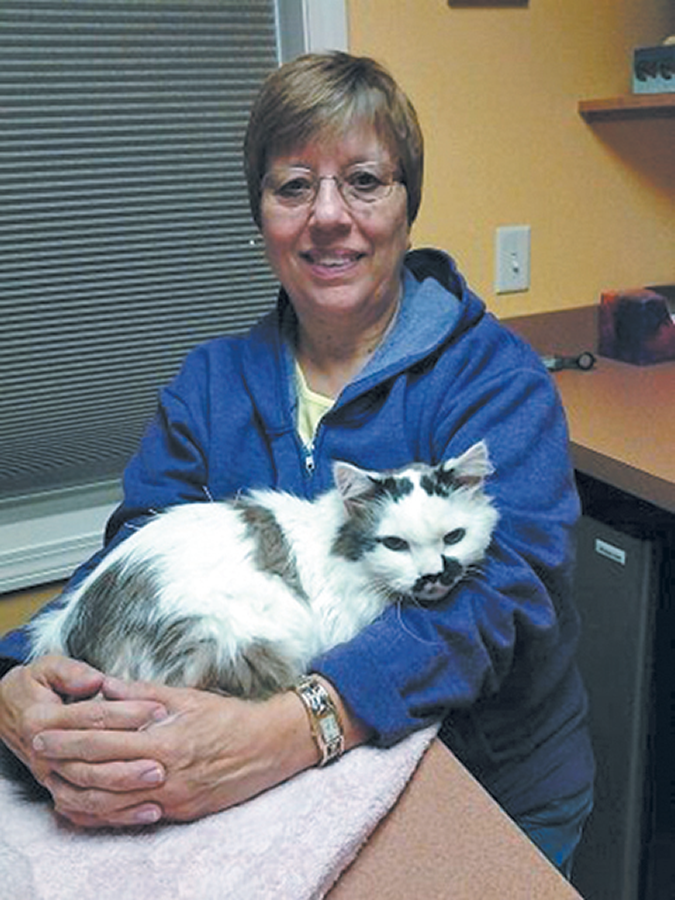 Chris Bibby sits with her cat