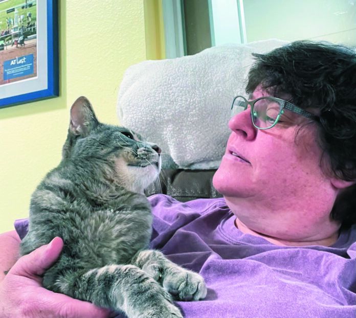 Veterinary technician Brandy Tabor with her own cat, Kitty Gumball. He’s clearly not in pain in this photo.